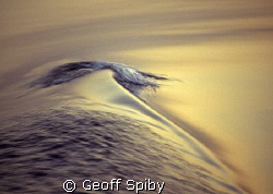 tiny wave caused by the boats wake on a flat sea by Geoff Spiby 